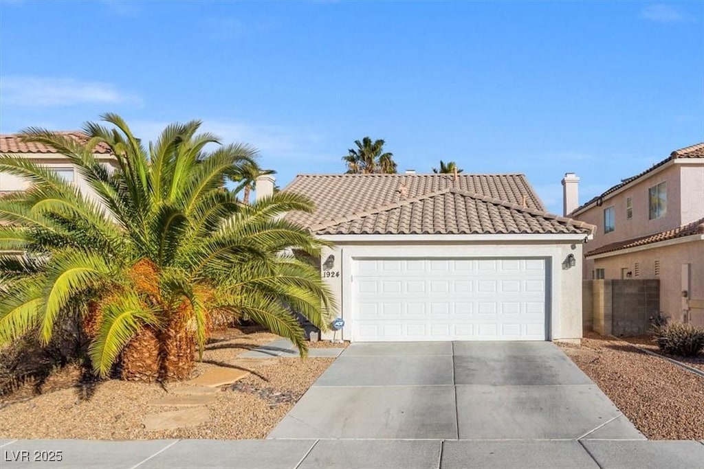 mediterranean / spanish-style home featuring driveway, stucco siding, an attached garage, and a tiled roof