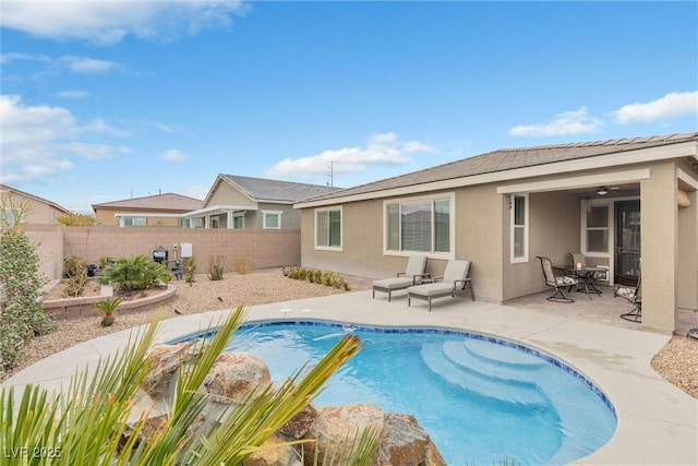 back of house with a patio area, a fenced backyard, a fenced in pool, and stucco siding