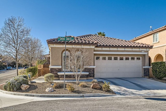 mediterranean / spanish-style home featuring stone siding, an attached garage, concrete driveway, and stucco siding