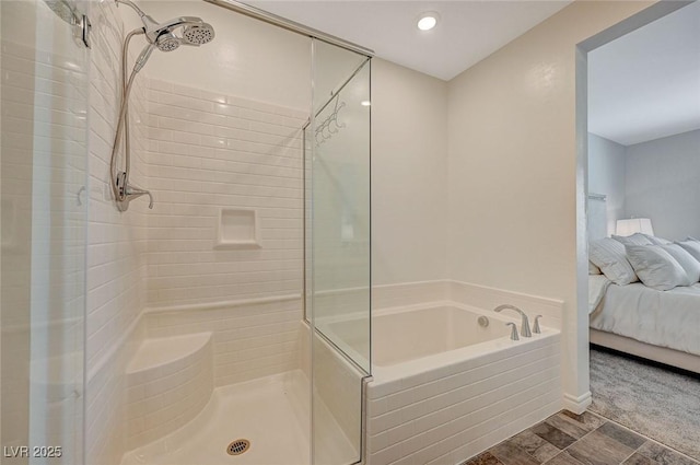 ensuite bathroom featuring a garden tub, a shower stall, and connected bathroom