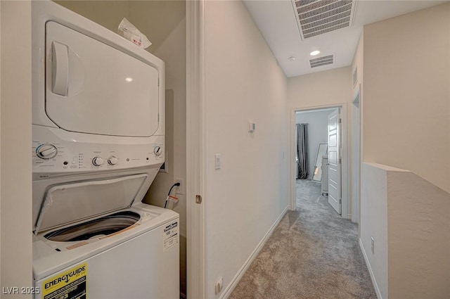 laundry area featuring stacked washer / dryer, baseboards, visible vents, and carpet flooring