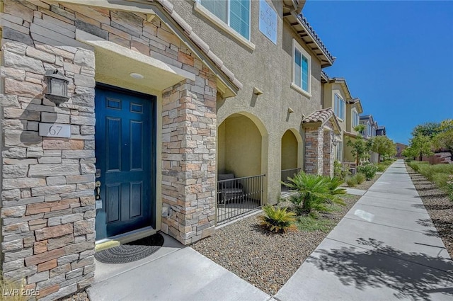 entrance to property featuring a residential view and stucco siding