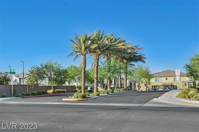 view of road featuring traffic signs, sidewalks, a residential view, and curbs