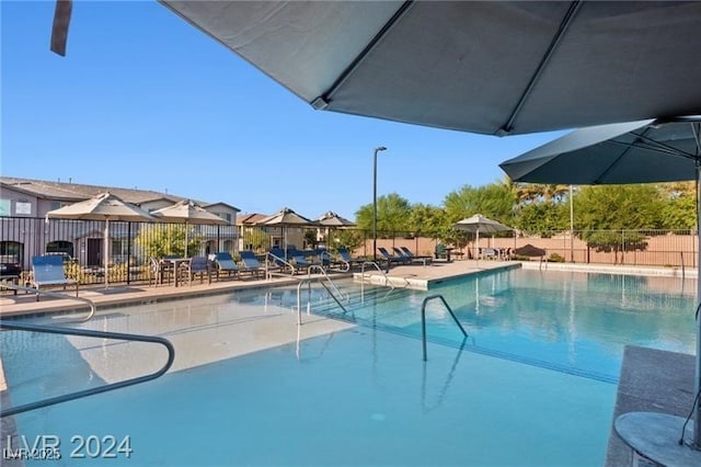 community pool with fence and a patio