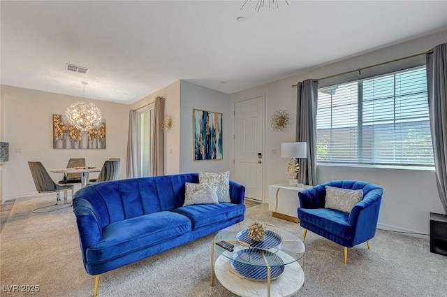 carpeted living room featuring an inviting chandelier, visible vents, and baseboards