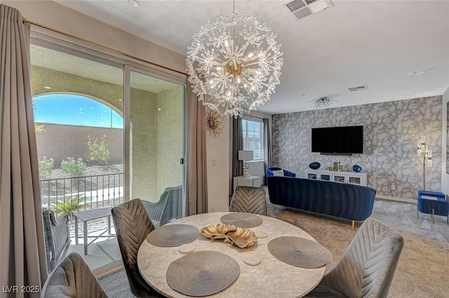 carpeted dining space with wallpapered walls, visible vents, and a notable chandelier