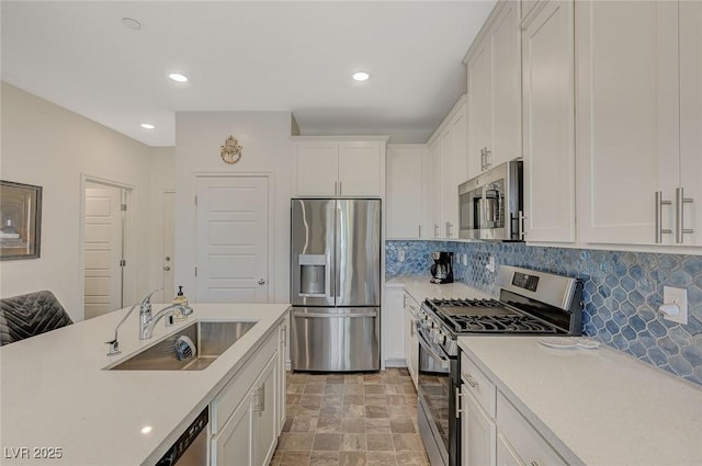 kitchen with white cabinets, appliances with stainless steel finishes, light countertops, and a sink