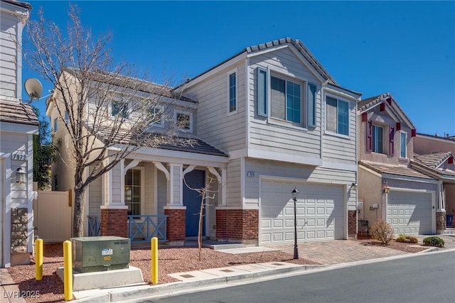 view of front of house with a garage, brick siding, decorative driveway, and a porch