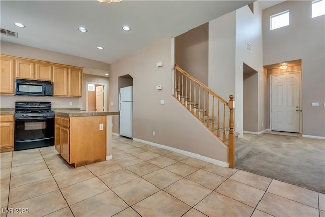 kitchen with a center island, visible vents, black appliances, and light tile patterned floors