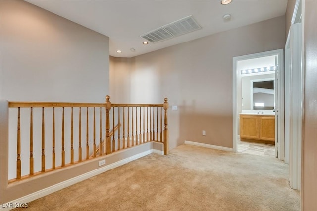 spare room with recessed lighting, visible vents, light carpet, and baseboards