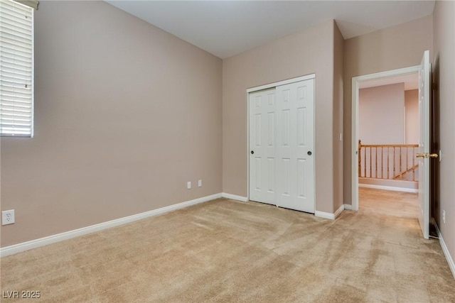 unfurnished bedroom featuring carpet, a closet, and baseboards