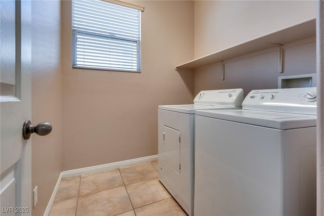 washroom featuring light tile patterned floors, laundry area, washing machine and dryer, and baseboards