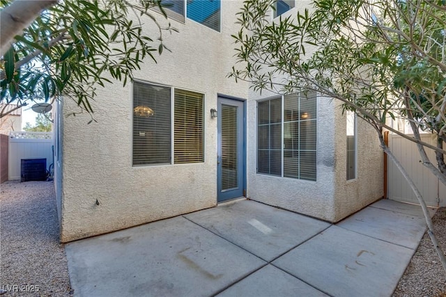 entrance to property featuring a patio, fence, a gate, and stucco siding