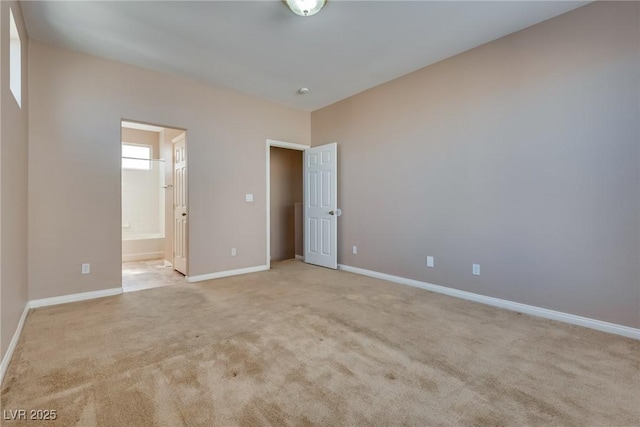 empty room with light colored carpet and baseboards