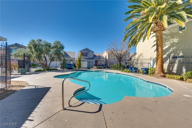 view of swimming pool featuring a residential view, fence, a fenced in pool, and a patio