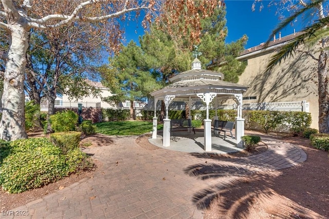 view of community with a gazebo, a patio area, and fence