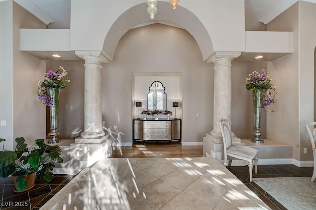 entrance foyer with arched walkways, decorative columns, and a towering ceiling