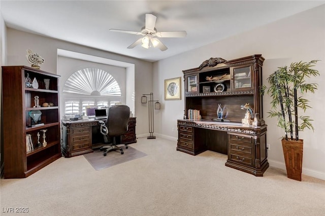 home office featuring baseboards, a ceiling fan, and light colored carpet