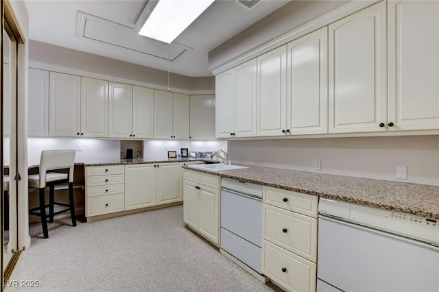 kitchen featuring visible vents, white cabinetry, a sink, light stone countertops, and dishwasher