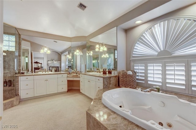 full bathroom featuring a stall shower, vaulted ceiling, a sink, and a whirlpool tub