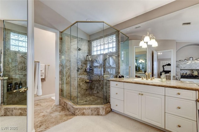 bathroom with visible vents, an inviting chandelier, vanity, a shower stall, and a fireplace