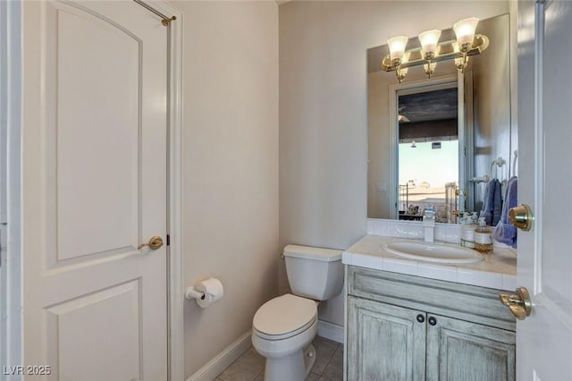 half bath with toilet, tile patterned flooring, baseboards, and vanity