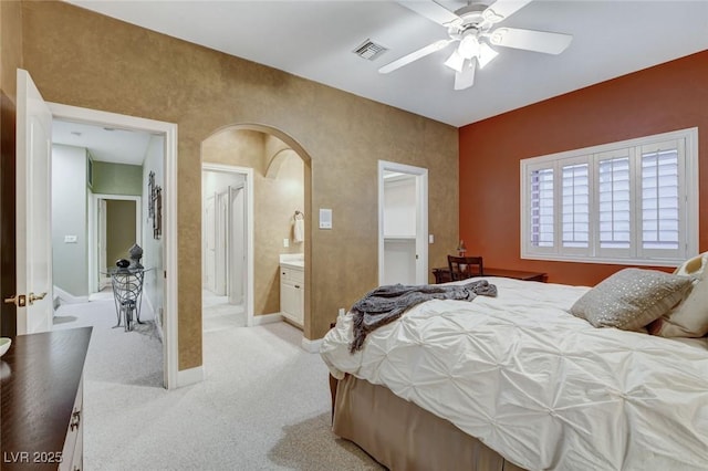 bedroom featuring arched walkways, visible vents, a ceiling fan, light carpet, and baseboards