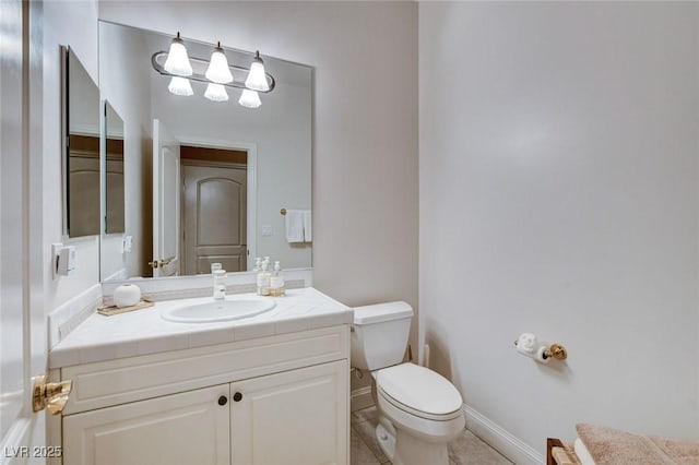 bathroom with tile patterned floors, vanity, toilet, and baseboards