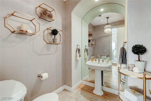 bathroom with toilet, baseboards, and tile patterned floors