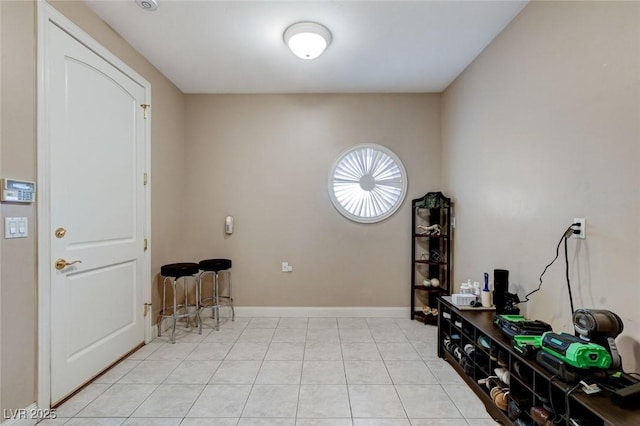 foyer entrance featuring baseboards and light tile patterned floors