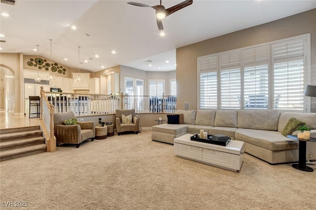 living area with ceiling fan, arched walkways, lofted ceiling, recessed lighting, and light colored carpet