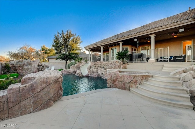 view of swimming pool with a fenced in pool, a water slide, and a patio