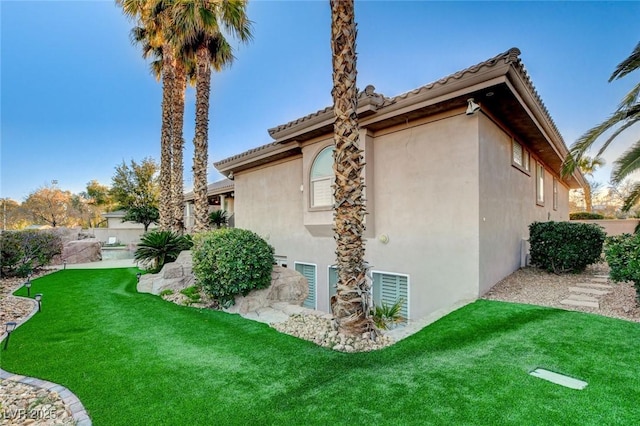 view of home's exterior featuring a lawn and stucco siding