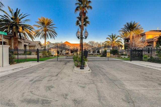 view of road with a gate, curbs, sidewalks, and a gated entry