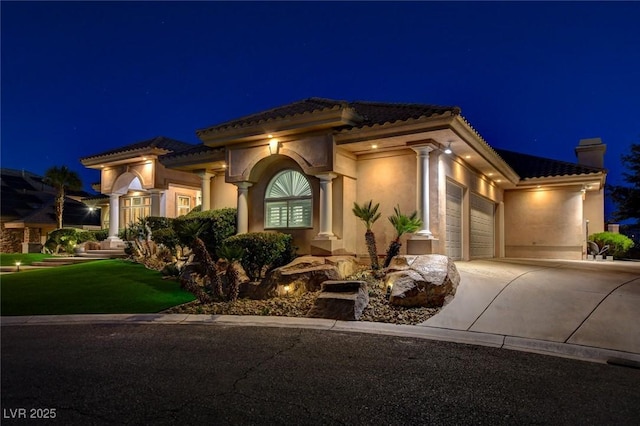 mediterranean / spanish-style house with driveway, a garage, a tile roof, a chimney, and stucco siding