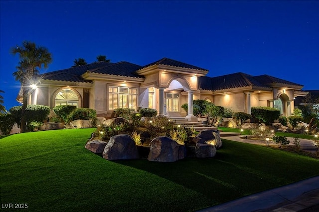 exterior space with french doors, a tile roof, a yard, and stucco siding