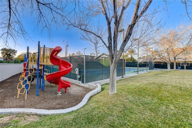 communal playground featuring fence and a lawn