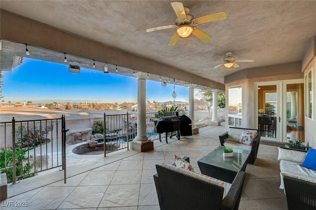 view of patio / terrace with fence, an outdoor living space, and a ceiling fan