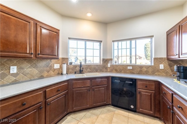 kitchen featuring a sink, tasteful backsplash, light countertops, and dishwasher