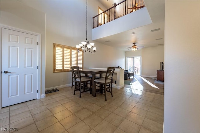 dining area featuring light tile patterned floors, visible vents, a high ceiling, and baseboards