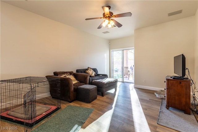 living room with a ceiling fan, wood finished floors, visible vents, and baseboards