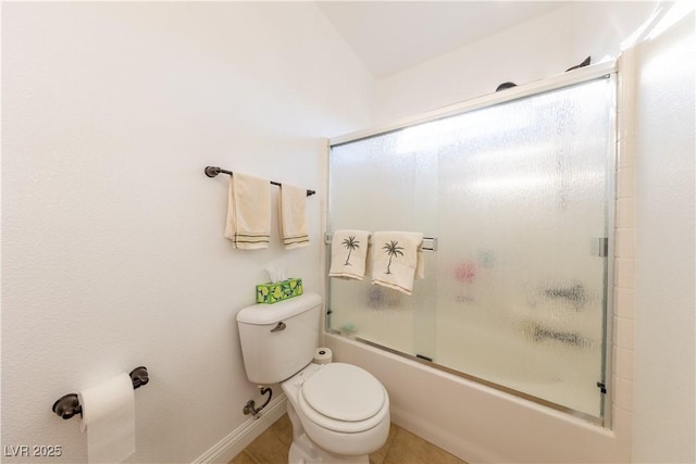 bathroom featuring toilet, shower / bath combination with glass door, and baseboards