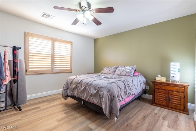 bedroom with baseboards, visible vents, ceiling fan, and light wood finished floors