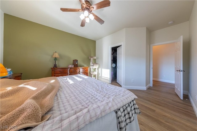 bedroom with a ceiling fan, a closet, baseboards, and wood finished floors