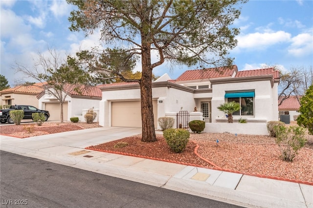 mediterranean / spanish-style house with a garage, a tile roof, concrete driveway, and stucco siding