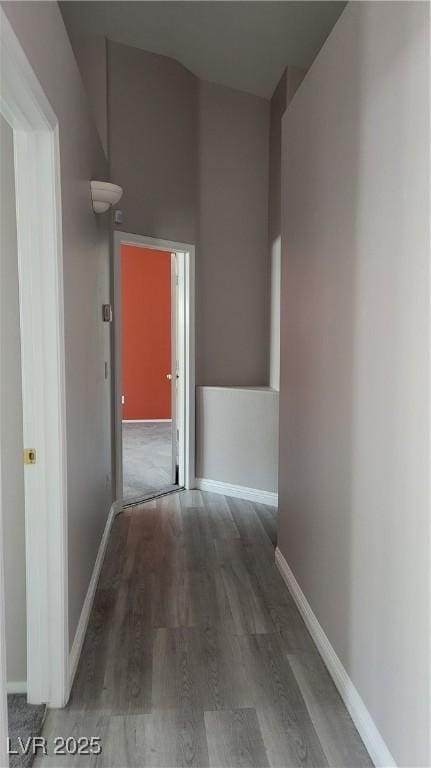 hallway featuring baseboards and wood finished floors