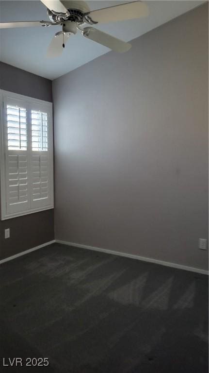 unfurnished room featuring baseboards, dark carpet, and ceiling fan