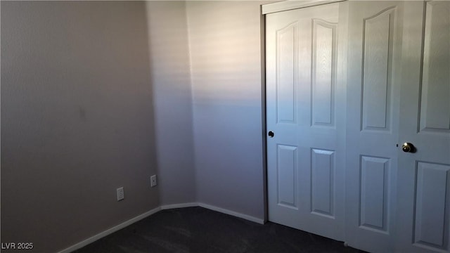 unfurnished bedroom with a closet and baseboards