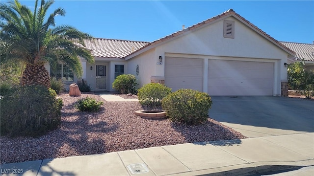 single story home with a tiled roof, stucco siding, driveway, and an attached garage