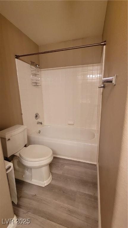 bathroom with toilet, shower / bath combination, and wood finished floors